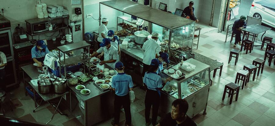 Cooks at work on a commercial kitchen line, seen from above